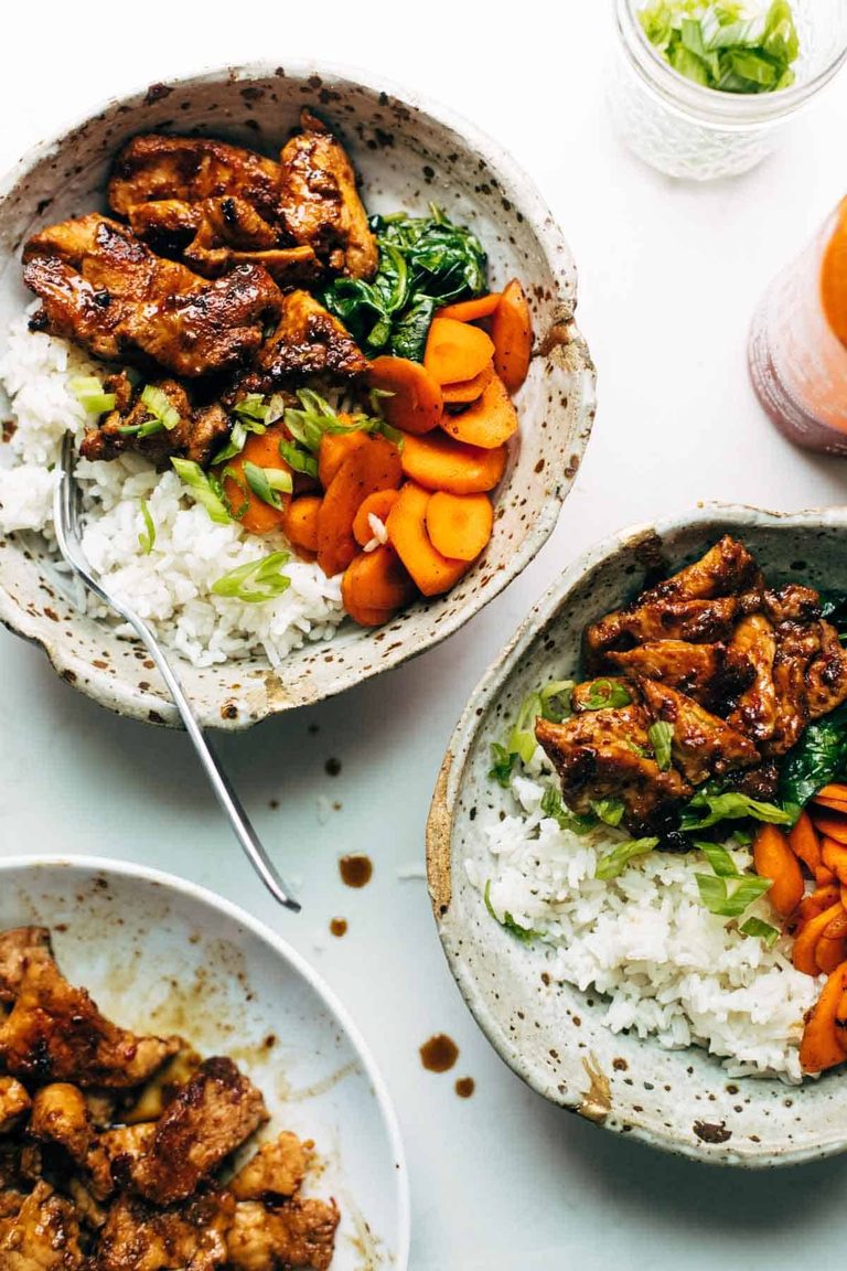 Spicy pork in bowls with rice and carrot.