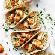 Buffalo Cauliflower Tacos on table in a row.