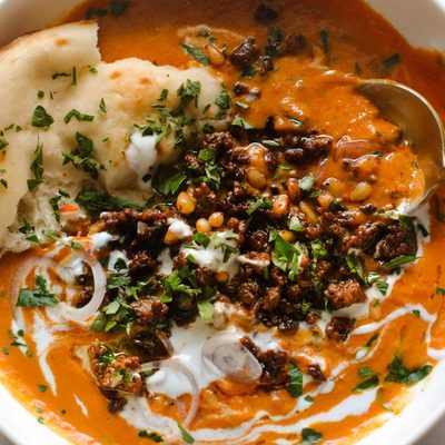 Carrot soup in a bowl with spiced ground beef.