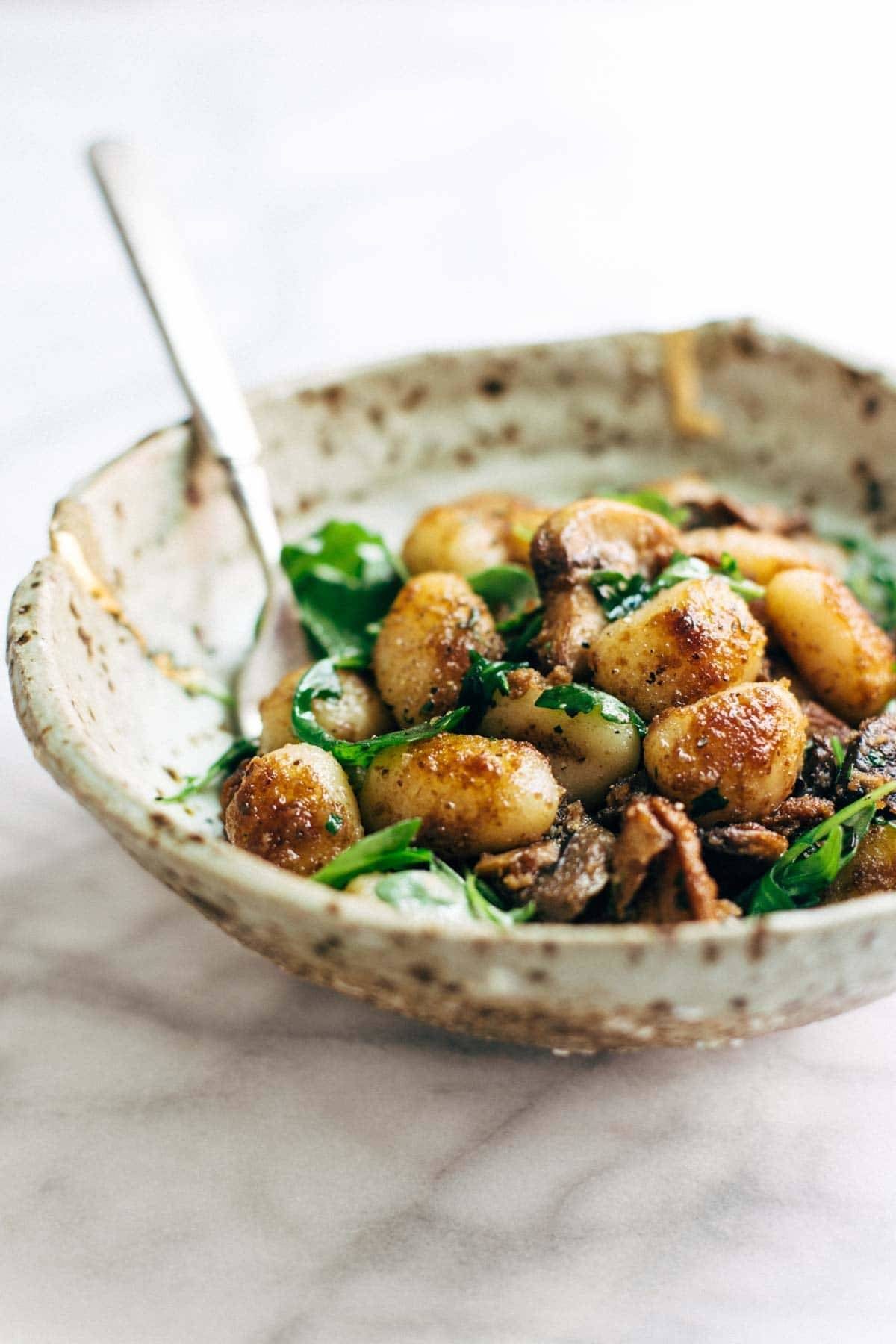Mushroom Gnocchi with Walnut Pesto and Arugula - a vegetarian bowl that's made with familiar ingredients. Comes together in 30 minutes or less! | pinchofyum.com