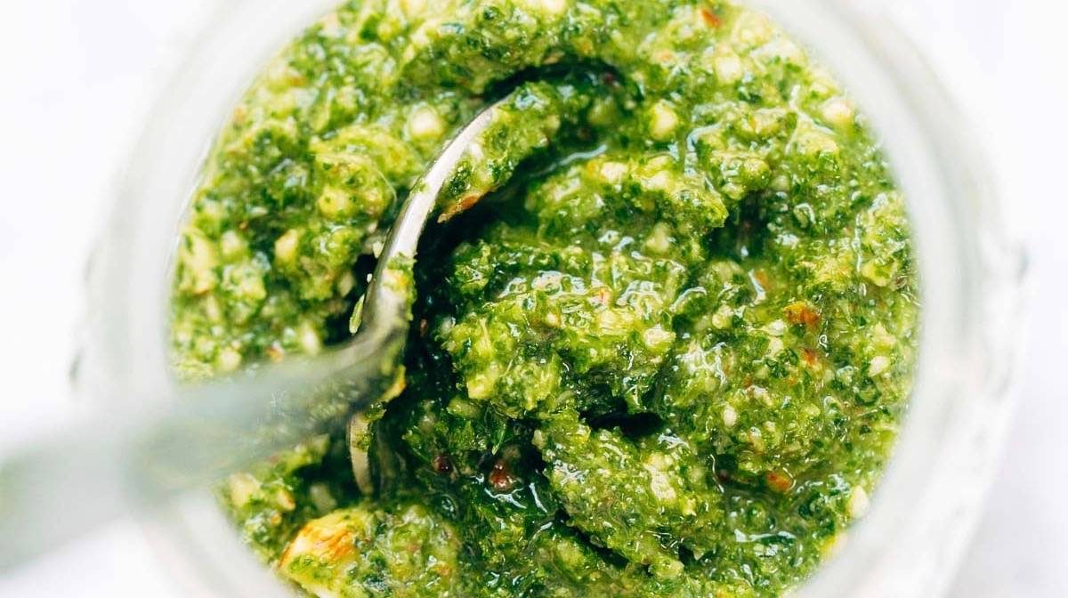 Kale Pesto in a jar with spoon.