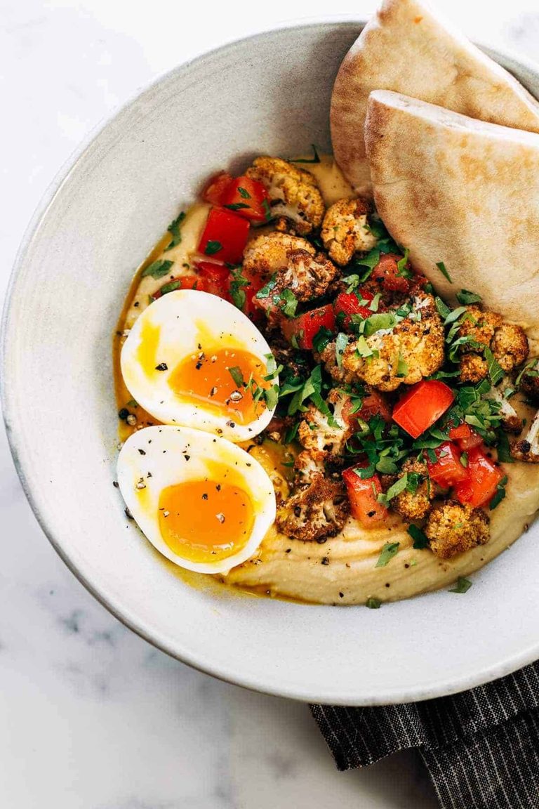 Hummus in a bowl topped with cauliflower.