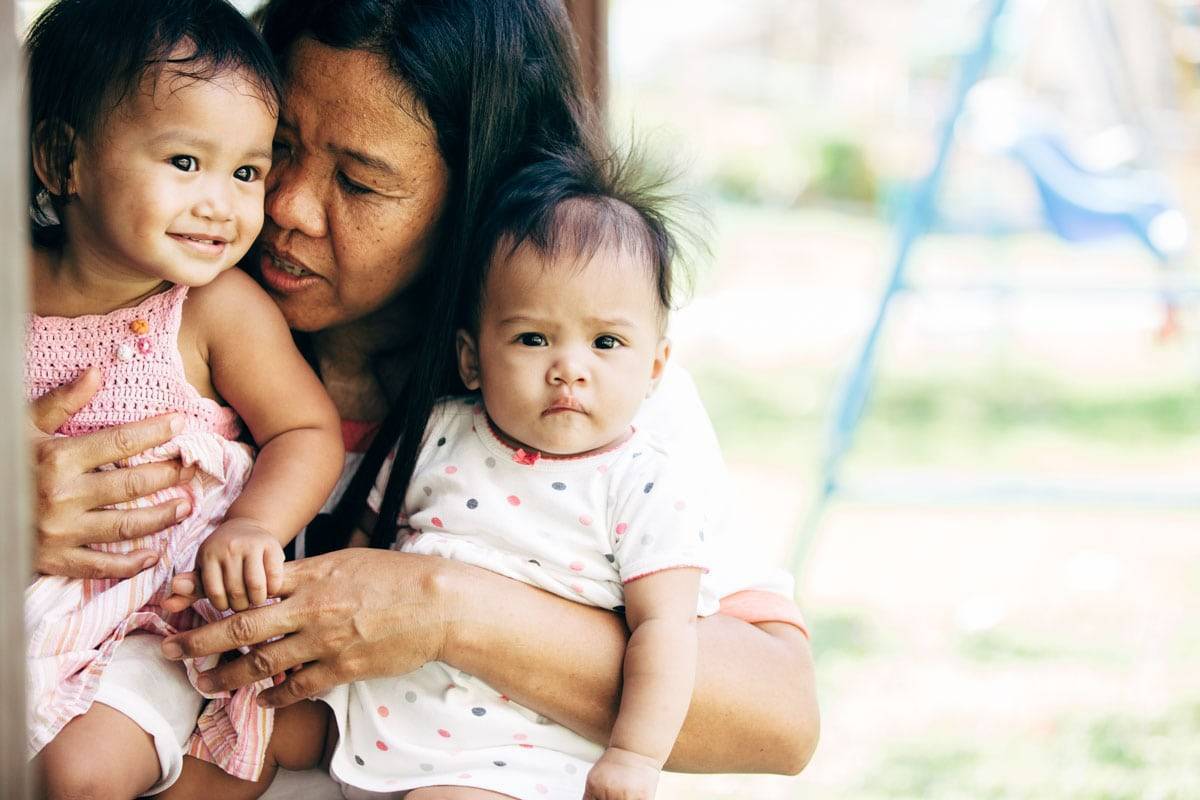 Woman holding two small girls.
