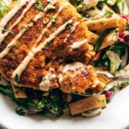 Salmon burgers on a bed of Mixed Greens in a bowl.