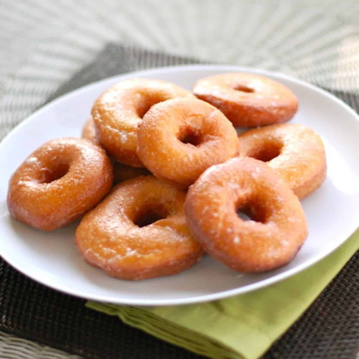 Sweet potato doughnuts on a plate on top of a green napkin.