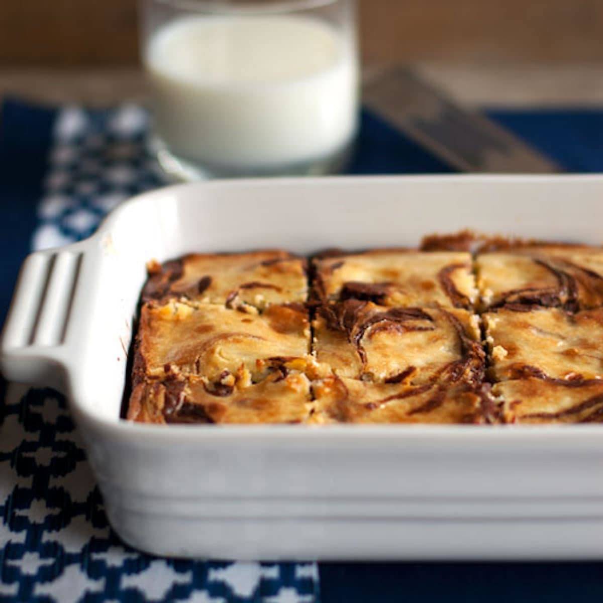 White chocolate cheesecake brownies in a white baking dish.